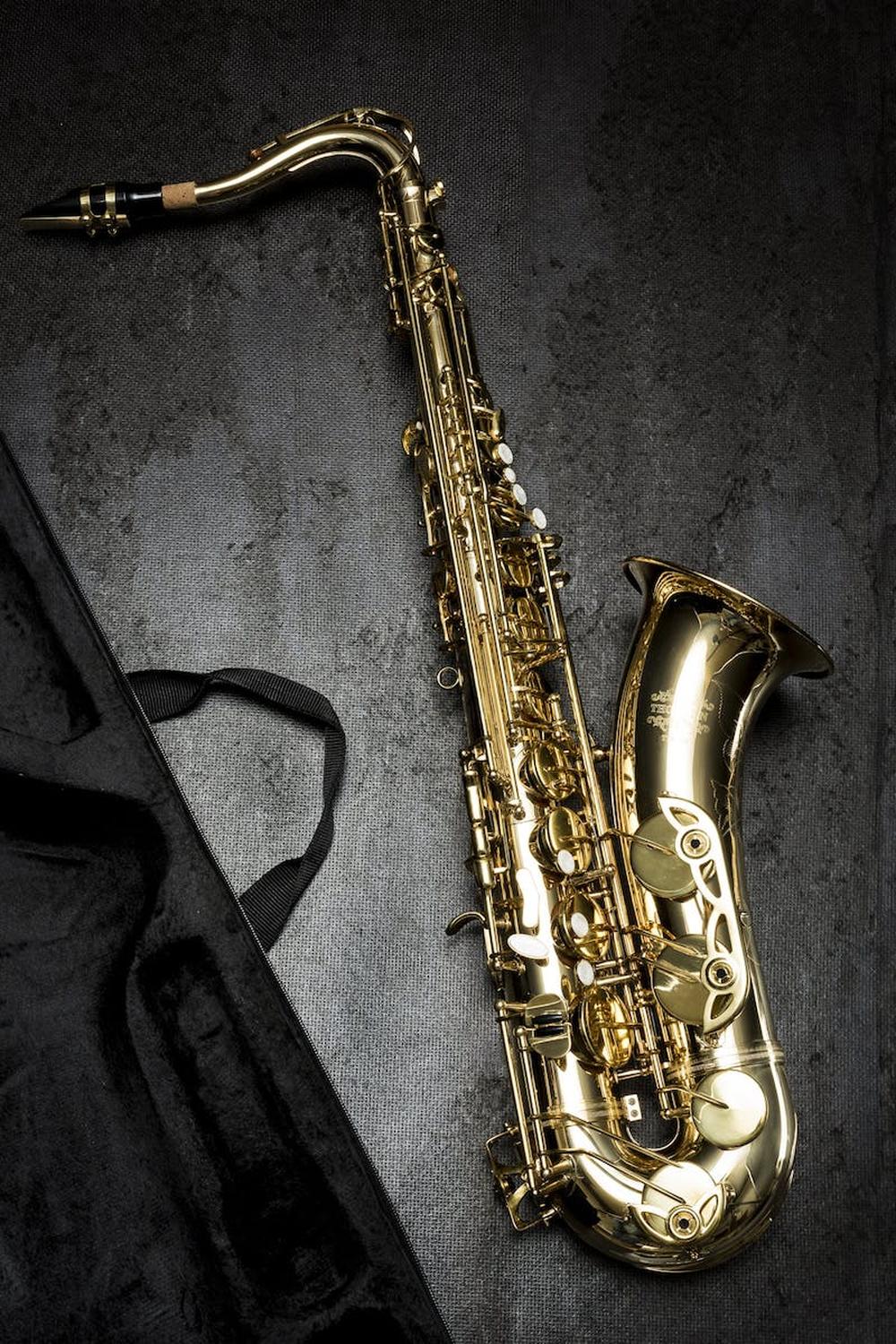 brass_saxophone_on_gray_table_near_black_bag